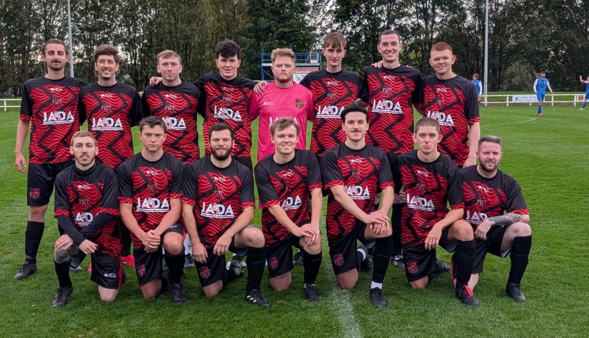 Team wearing ADG kit – white and green match kit on pitch